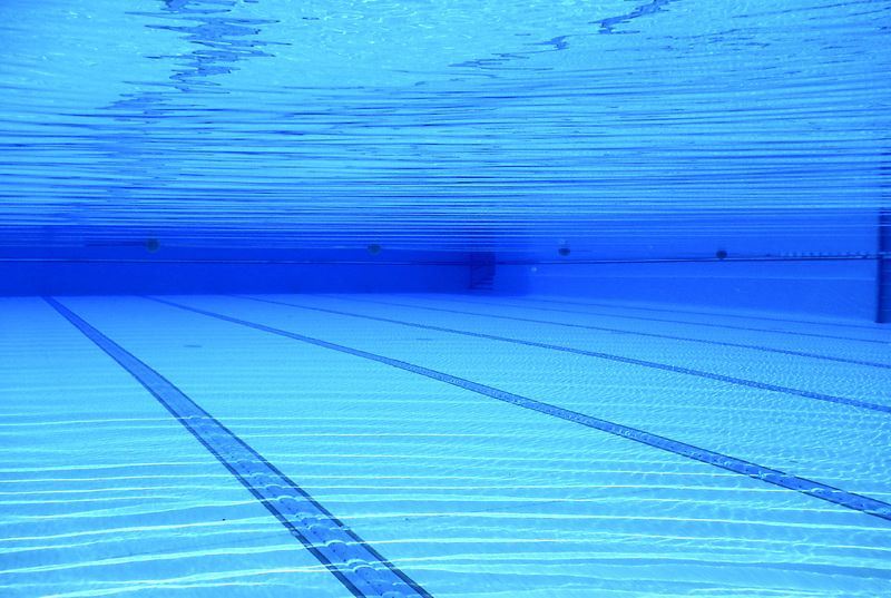 Underwater image showing swimming pool water surface and lane line