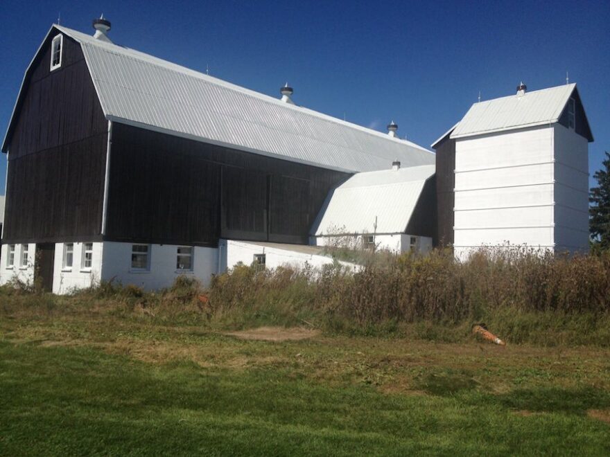 Exterior view of a barn being painted as part of farm building maintenance